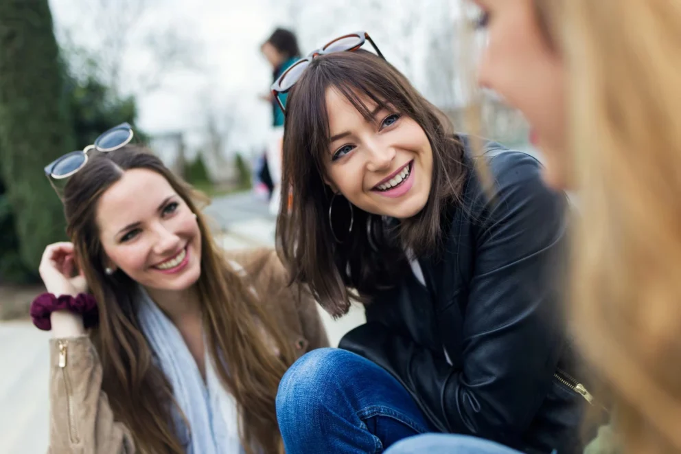 three-young-women-talking-laughing-street_1301-3350