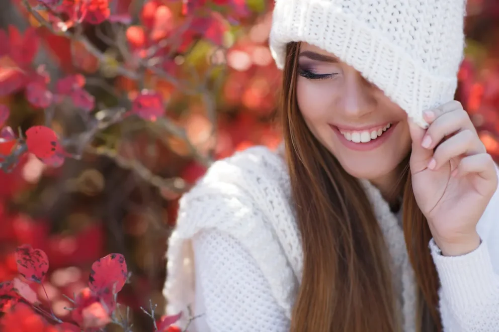 beautiful woman smiling while being outdoors on a flower scenery