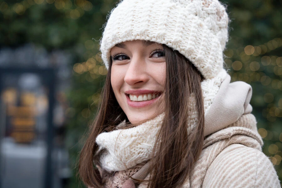 Beautiful woman with a beanie smiling while outdoors